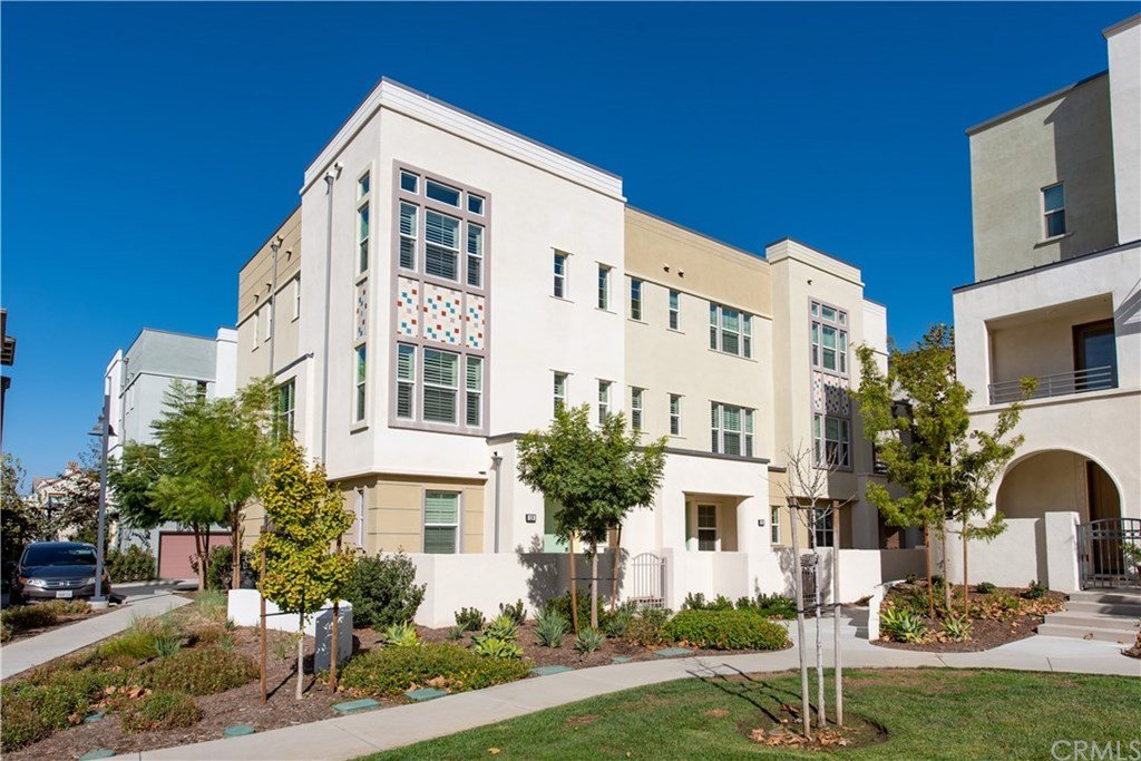 Exterior of condominium building with walking paths and trees in Irvine's Great Park neighborhood