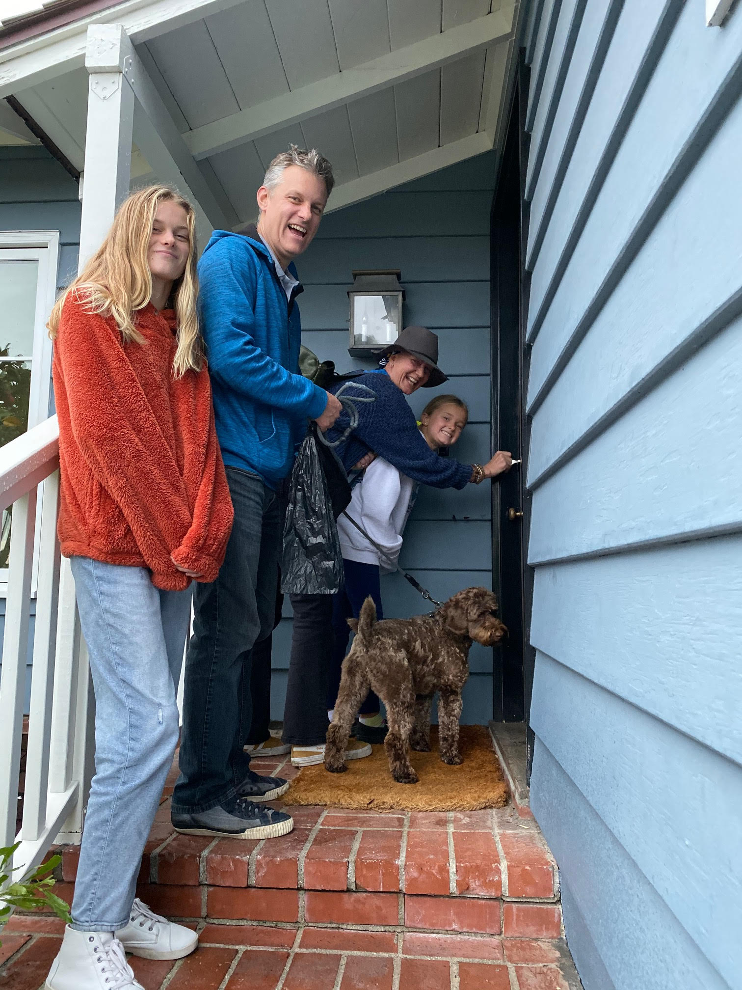 New Buyers And Their Dog Accepting The Keys To Their New Blue Home