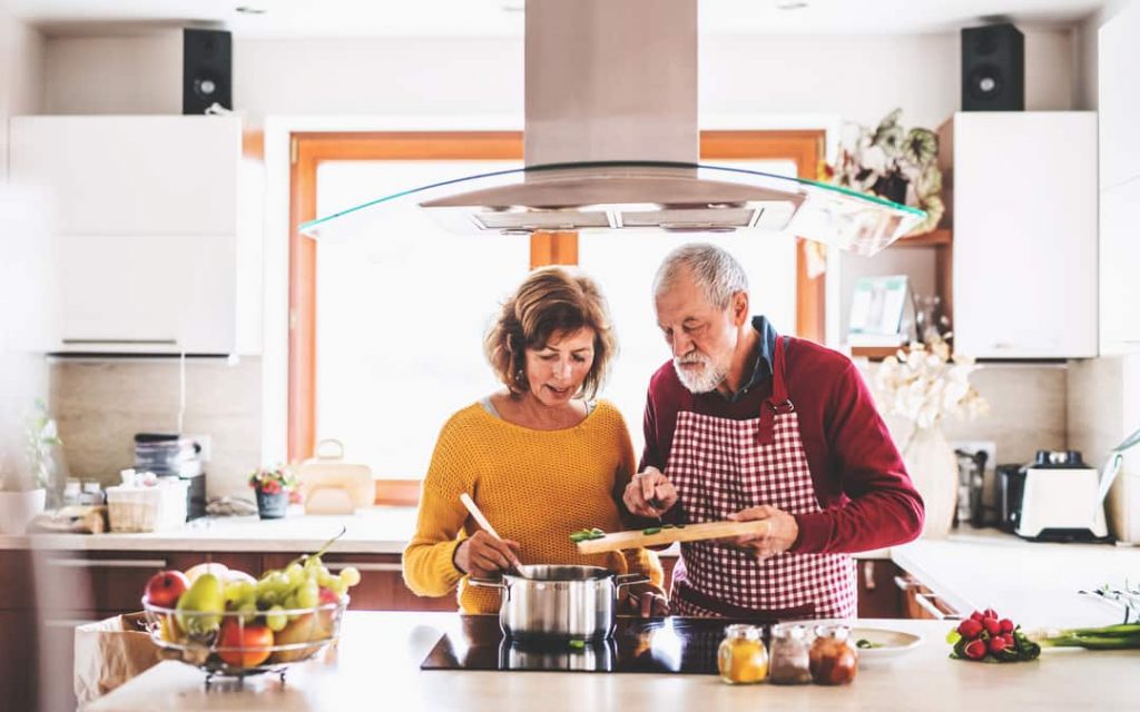 Senior Couple Preparing Food In The Kitchen