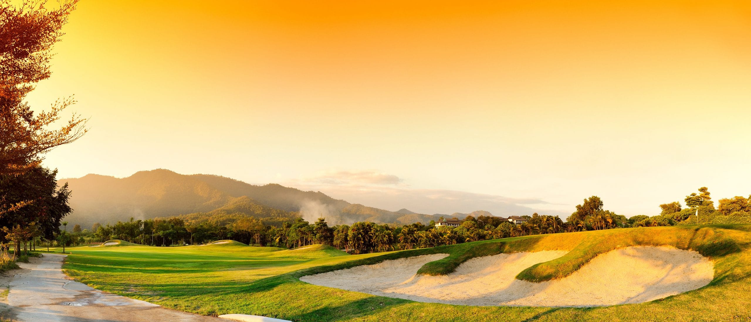 Golf Course At Sunset With Mountains In Background
